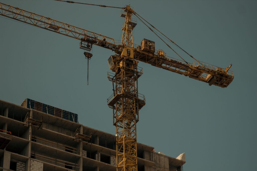 Grúa torre elevándose sobre una obra en construcción